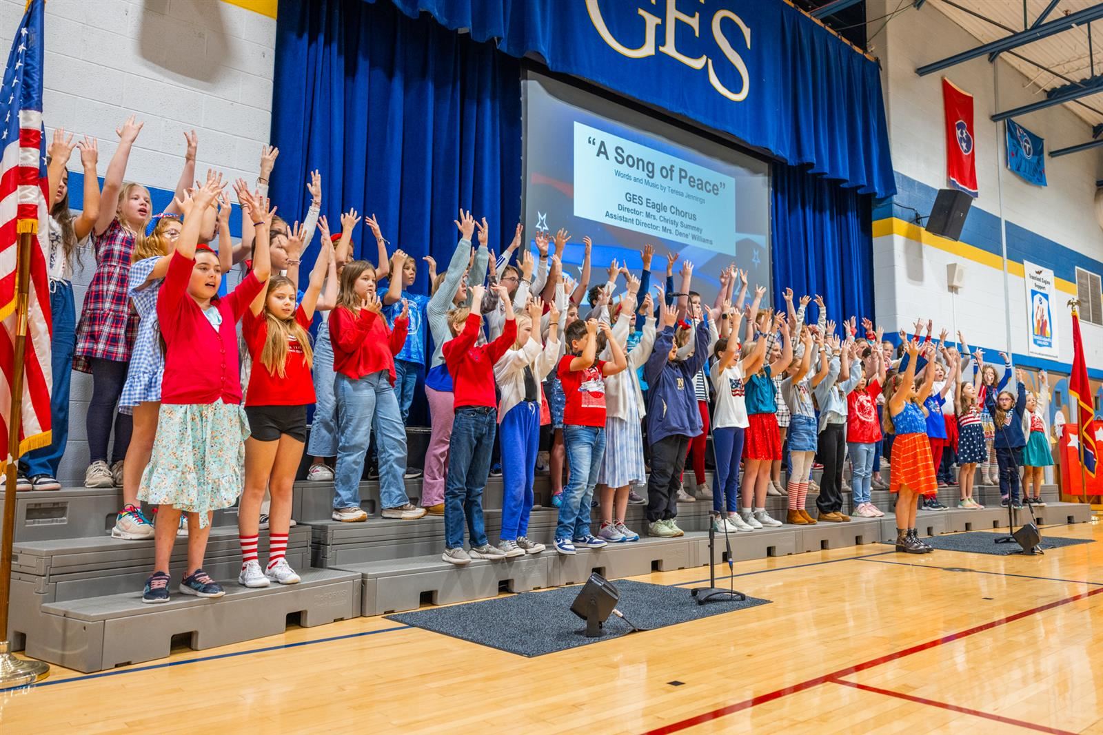 students singing with arms in the air